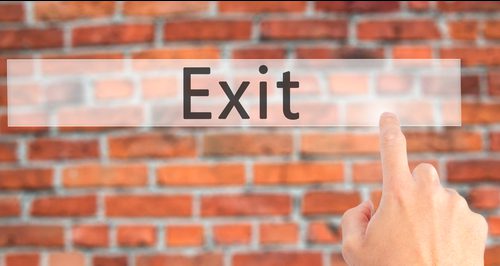 Exit - Hand pressing a button on blurred background concept on v