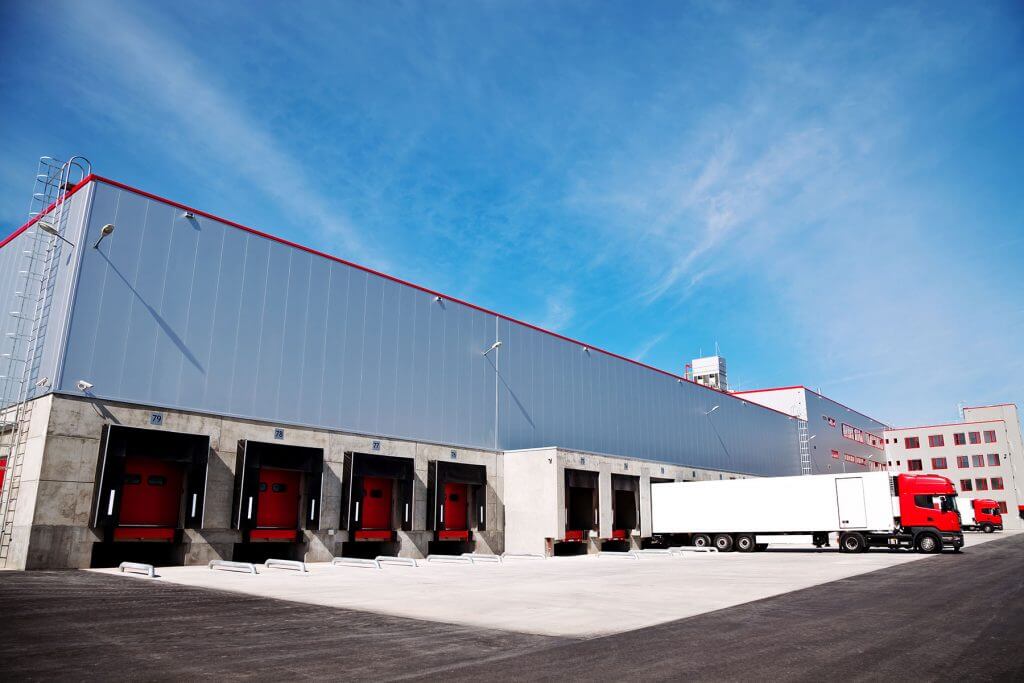 Picture of a warehouse with a truck loading product in