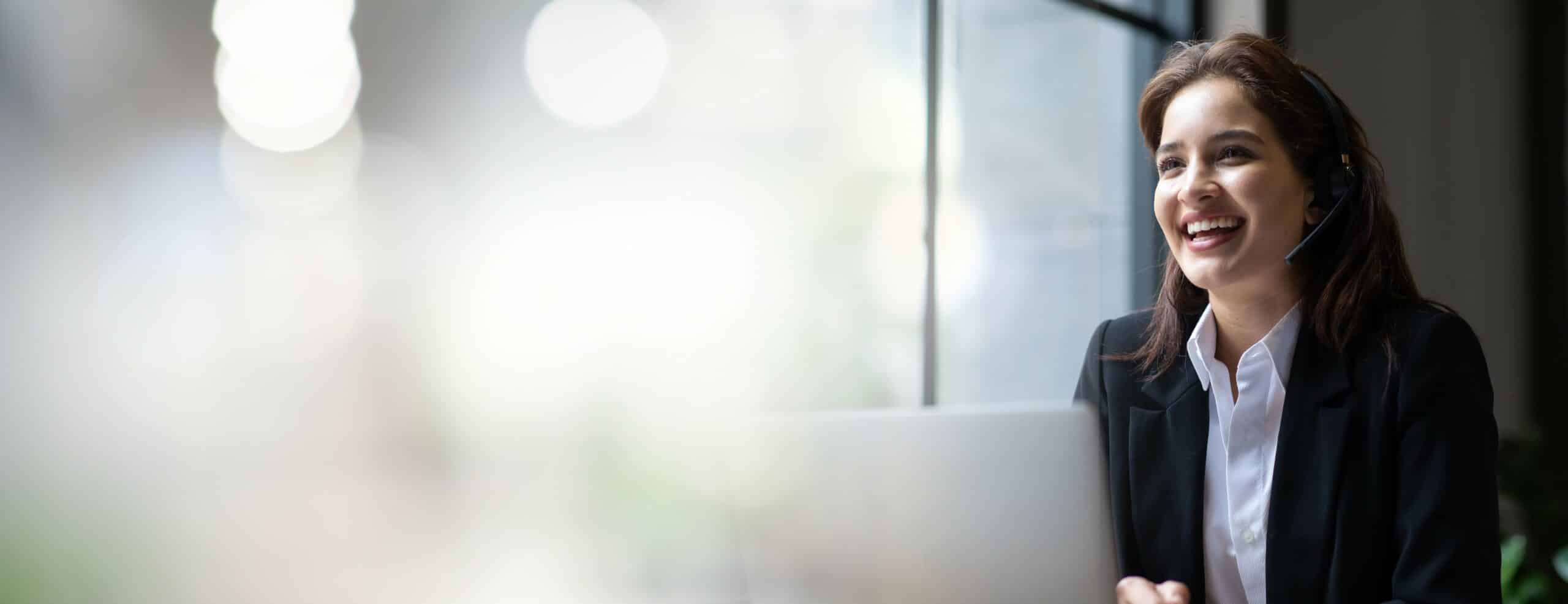 businesswoman with laptop and headset smiling