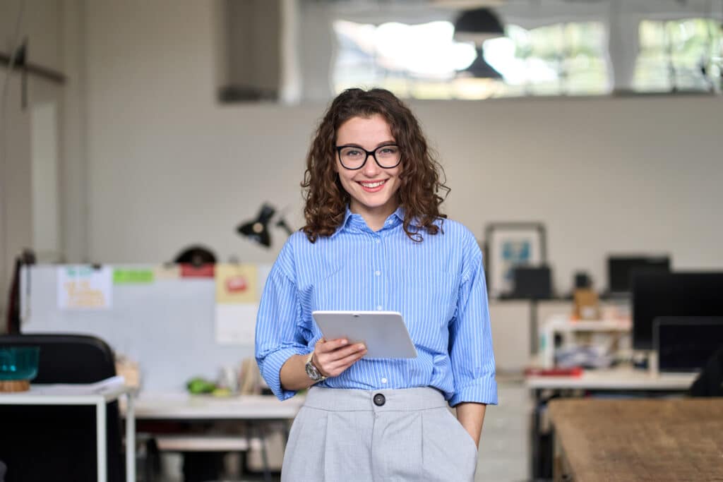 woman with glasses holding a tablet