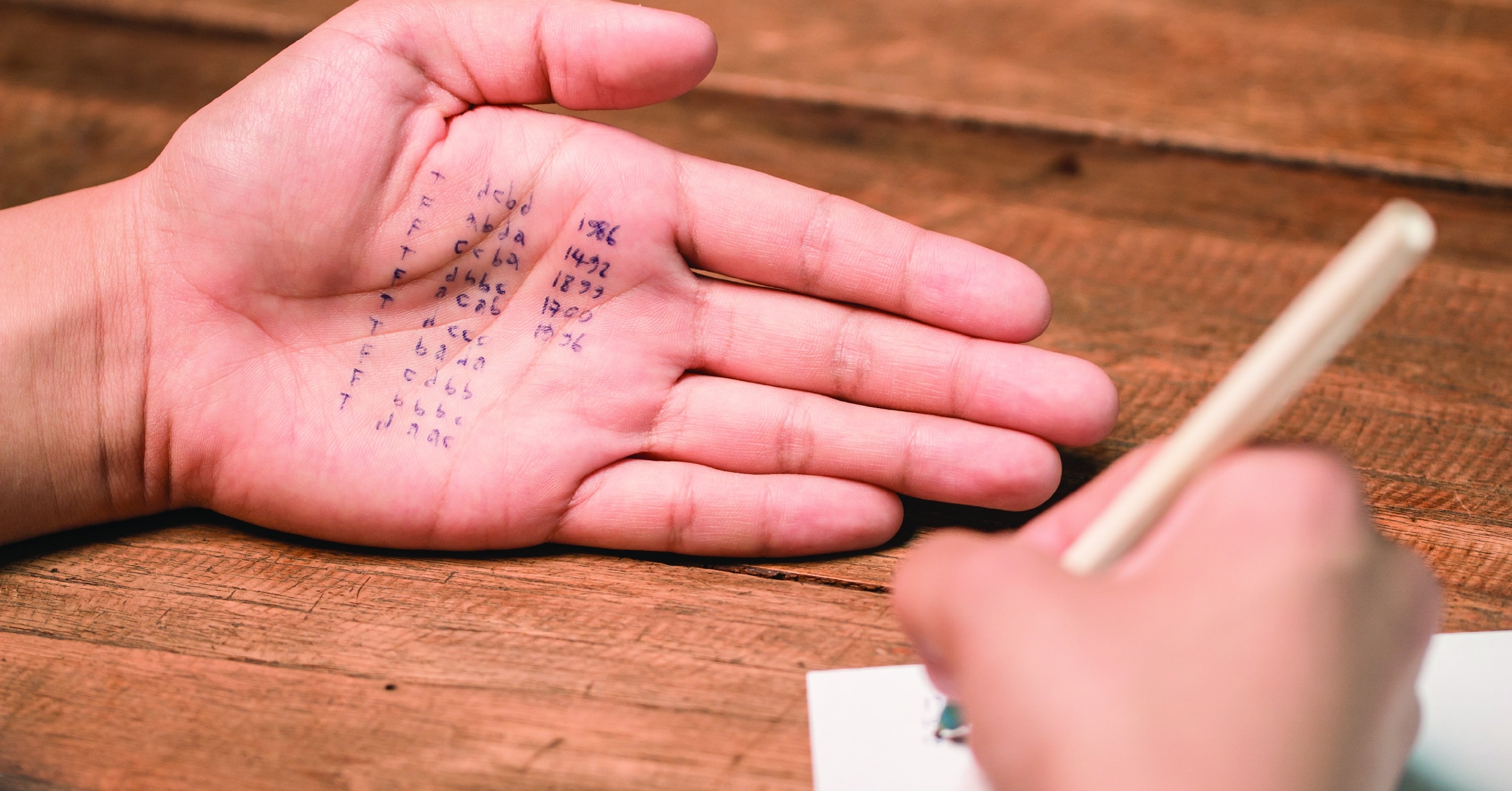 Person using a cheat sheet they wrote on their hand.
